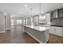Open-concept kitchen with island, stainless steel appliances, and view into the living room at 2321 Calluna Ct, Fuquay Varina, NC 27526