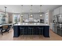 Gourmet kitchen featuring a large island with seating, pendant lighting, and modern appliances at 2609 Aster Ct, Apex, NC 27502