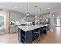 Bright and airy kitchen featuring a large island with seating, stainless steel appliances, and custom cabinetry at 2609 Aster Ct, Apex, NC 27502
