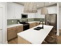 Bright kitchen featuring stainless steel appliances, two-toned cabinetry, a tile backsplash, and large center island with seating at 264 Beacon Dr, Pittsboro, NC 27312