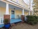 Inviting front porch with blue floor, rocking chair, and brick supports at 298 E Salisbury St, Pittsboro, NC 27312