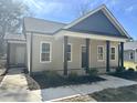 Close-up of a cozy home with a covered front porch, showcasing the neutral siding and dark accent columns at 314 S Darden St, Kenly, NC 27542