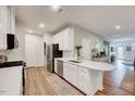 Bright kitchen featuring white cabinets, stainless steel appliances, and wood flooring at 408 Judge Ct, Durham, NC 27703