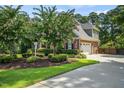 Brick home featuring manicured lawn, flowering trees, and attached two car garage at 5708 Creekfall Ln, Fuquay Varina, NC 27526