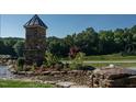 Stone entrance feature, well-manicured landscape, and a small, decorative water feature at 59 Riverstone Dr, Pittsboro, NC 27312
