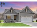 Charming gray home with a two-car garage, gray roof, and manicured lawn and professional landscaping at 60 Pintail Lane Ln, Youngsville, NC 27596