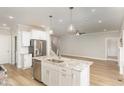Open floor plan kitchen with granite counters, stainless appliances, and kitchen island overlooking living area at 60 Pintail Lane Ln, Youngsville, NC 27596