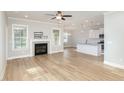 Bright living room with fireplace, ceiling fan, wood floors, and open floor plan to the kitchen at 60 Pintail Lane Ln, Youngsville, NC 27596