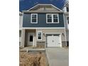 New two-story townhome featuring attached garage, stone accents, neutral siding, and a white front door at 62 Shay St, Angier, NC 27501
