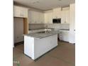 A kitchen showcasing an island with granite countertop, stainless steel appliances, and all-white cabinets at 62 Shay St, Angier, NC 27501
