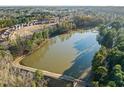 Scenic aerial view of a serene lake surrounded by lush trees and a quaint neighborhood at 1027 Laurelwood Dr, Durham, NC 27705
