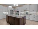 Modern kitchen boasts white cabinets, granite counters, stainless appliances, and a large center island at 1027 Laurelwood Dr, Durham, NC 27705