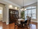 Elegant dining room featuring hardwood floors, a large window, and a stylish chandelier at 1028 Dotson Way, Apex, NC 27523