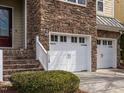 Close up of the garage, with number 1028 on side. Has white garage doors and stone wall at 1028 Dotson Way, Apex, NC 27523