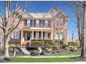 Charming brick two-story home with a manicured lawn and a welcoming front porch at 109 Skywater Ln, Holly Springs, NC 27540