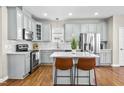 Modern kitchen features stainless steel appliances, granite countertops, and island with seating at 112 Bally Shannon Way, Apex, NC 27539