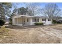 Inviting white brick home featuring a covered carport and landscaped front yard at 11254 Hwy Nc 50, Benson, NC 27504