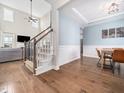 Bright foyer featuring hardwood floors, a staircase, and views into the living and dining areas at 115 Lockamy Ln, Youngsville, NC 27596