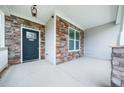 Close-up of front porch showcasing the stone accents, stylish door, and modern outdoor lighting at 115 Lockamy Ln, Youngsville, NC 27596