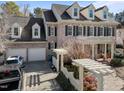 Beautiful home with an attached two-car garage, manicured yard, and a classic brick facade with dark shutters at 12344 Canolder St, Raleigh, NC 27614