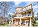 Expansive rear exterior featuring a brick patio, upper and lower decks, and a well-maintained yard at 12345 Beestone Ln, Raleigh, NC 27614