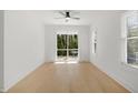 Bright bedroom with a ceiling fan, light hardwood floors, and sliding glass doors to a balcony at 1410 Joe Louis Ave, Raleigh, NC 27610