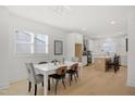 Bright dining room with hardwood floors open to the kitchen, featuring a white table with seating for six at 1410 Joe Louis Ave, Raleigh, NC 27610