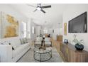Open-concept living room with hardwood floors, modern furnishings, and a view into the dining and kitchen areas at 1410 Joe Louis Ave, Raleigh, NC 27610