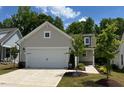 Inviting home with a two-car garage, neutral exterior, and a beautifully landscaped front yard at 1413 Buxus Ct, Fuquay Varina, NC 27526