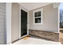 Welcoming front entry with a black door, decorative brick detail, and a charming 'HELLO' doormat at 1413 Buxus Ct, Fuquay Varina, NC 27526