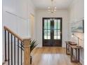 Elegant foyer with hardwood floors, wainscoting, and a stylish chandelier at 15 Harvest View Way, Franklinton, NC 27525
