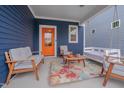Inviting front porch featuring comfortable seating, a porch swing, and a colorful rug, perfect for enjoying the outdoors at 1520 Rhodeschool Dr, Wendell, NC 27591