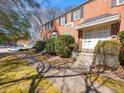 Well-maintained red brick townhome with inviting walkway, lush greenery, and ample parking at 1603 Sutton Dr, Raleigh, NC 27605