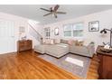 Bright living room with hardwood floors, a large sectional couch, and updated ceiling fan at 1603 Sutton Dr, Raleigh, NC 27605