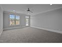 Bright and airy bedroom features plush carpeting, natural light, and a ceiling fan at 201 Finsbury St # 302, Durham, NC 27703