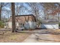 Exterior home view with a long driveway leading to the detached garage, surrounded by trees at 214 Woodcrest Ave, Smithfield, NC 27577