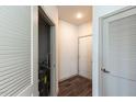 Hallway with gray trim, wood floors, and access to a storage closet at 2300 Gathering Sq Ct, Fuquay Varina, NC 27526