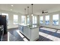 Modern kitchen features a large island, granite counters, stainless appliances, and lots of windows at 2300 Gathering Sq Ct, Fuquay Varina, NC 27526