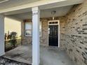 Welcoming front porch with brick siding, sturdy support beams, and a classic black front door at 264 Steel Hopper Way, Garner, NC 27529