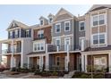Charming multi-story townhomes with appealing exteriors, showcasing architectural details and curb appeal in a pleasant setting at 2929 Great Lawn Rd, Apex, NC 27502