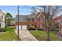 Charming two-story brick home with a well-manicured lawn, attached two-car garage, and mature landscaping at 3208 Marblewood Ct, Raleigh, NC 27604