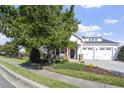 Beautiful home with mature trees, an American flag, and a manicured front lawn at 338 Wildwind Dr, Chapel Hill, NC 27516