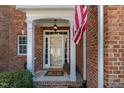 Welcoming front porch with white columns, showcasing brick facade and American flag at 3924 Sunset Maple Ct, Raleigh, NC 27612