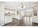 Bright kitchen with white cabinets, pendant lighting, gray wood floors and an open floor plan at 405 Coral Creek Ln, Morrisville, NC 27560