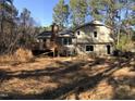 Backyard view featuring an elevated wooden deck and mature trees at 4401 Sprague Rd, Raleigh, NC 27613