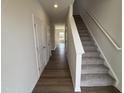Bright entryway with hardwood floors, white walls, a staircase, and access to other rooms at 52 Commons Cir, Clayton, NC 27520