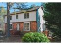 This two-story home boasts a brick facade, contrasting siding, and a lush green bush in the front yard at 5520 Sweetbriar Dr, Raleigh, NC 27609