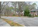 Traditional two-story home nestled among mature trees, complemented by a well-kept lawn and quiet street at 5520 Sweetbriar Dr, Raleigh, NC 27609
