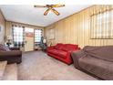 Cozy living room with wood paneling, ceiling fan, carpet, and furniture arrangement at 722 Forge Rd, Durham, NC 27713