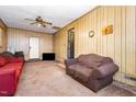 A second view of the living room with wood paneling, carpet, furniture and a television at 722 Forge Rd, Durham, NC 27713